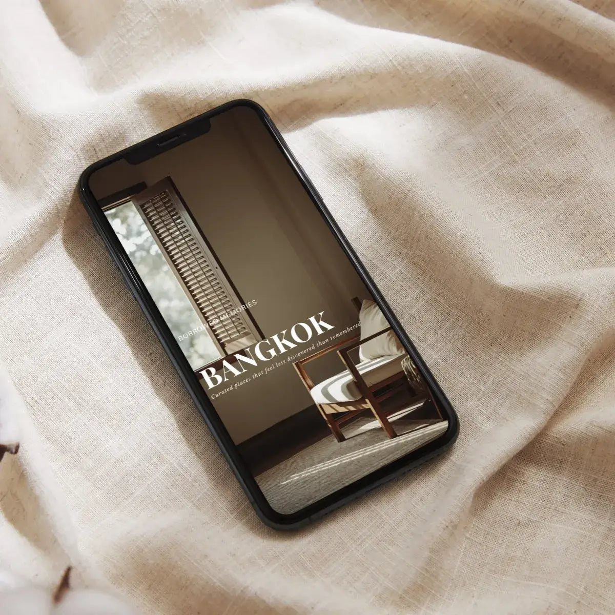 Bangkok travel guide - cinematic digital guide displayed on a smartphone resting on fabric, showcasing a stylish interior.