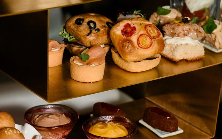 Assorted small food items on a gold tray at  Kimpton_Maa-Lai_Bangkok