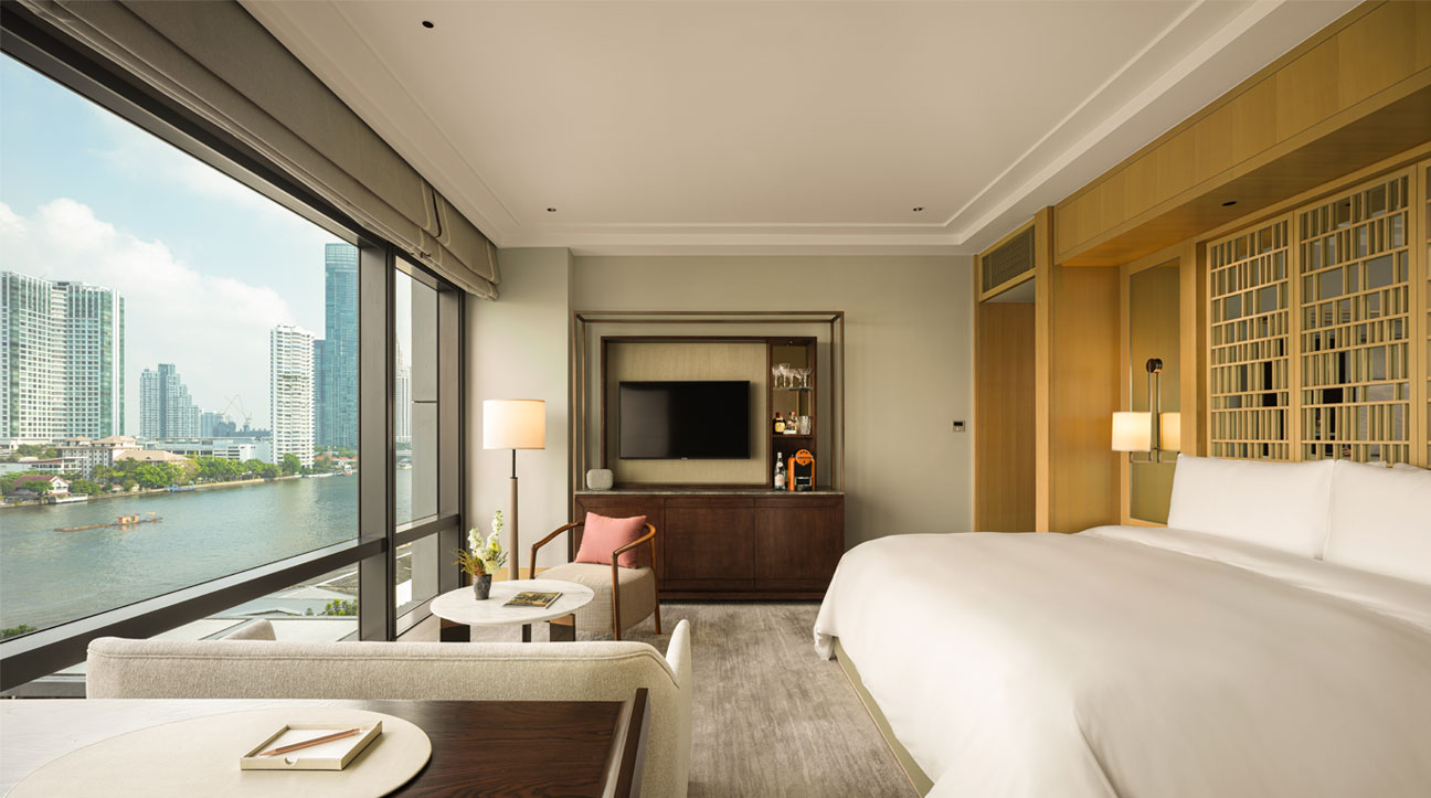Modern hotel room with cityscape view, bed, and television at Capella hotel Bangkok