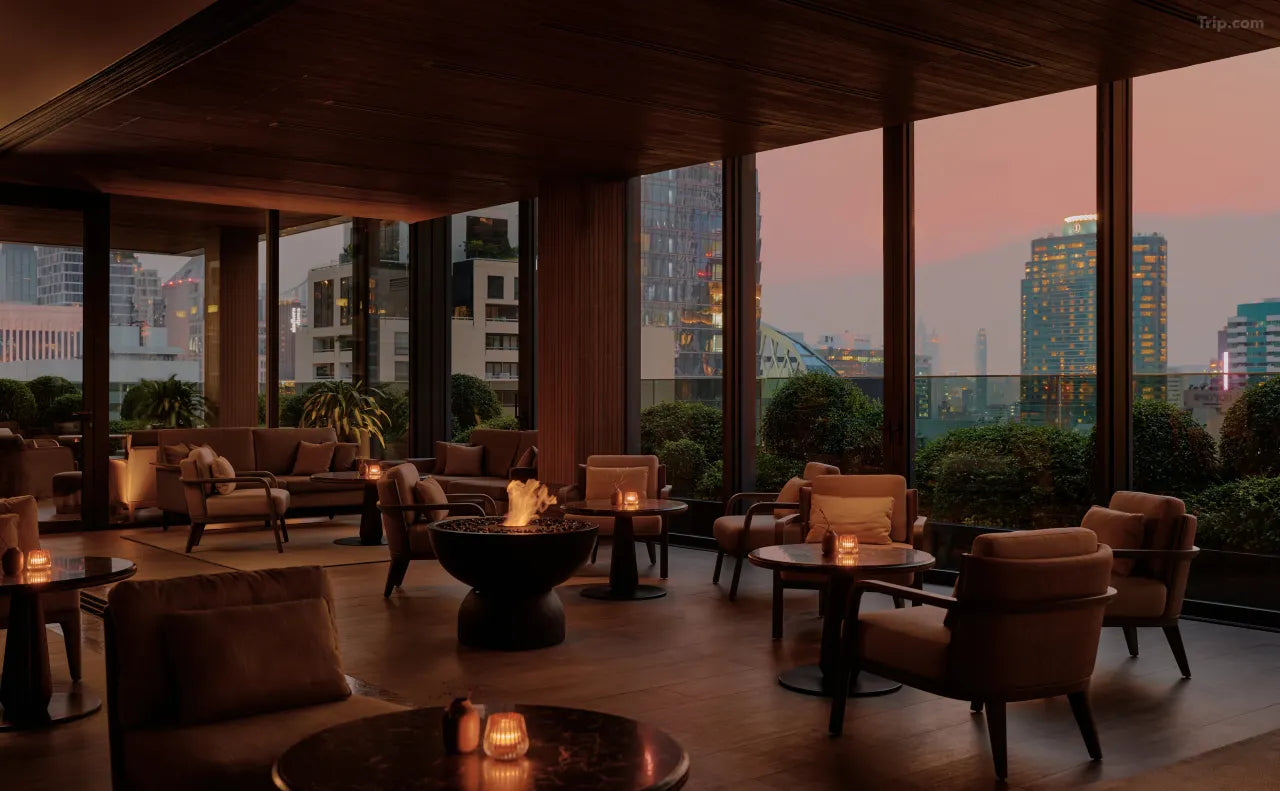 Aman Nai Lert Bangkok lounge with city skyline, warm ambiance, luxury hotel Bangkok